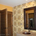 A photo of the ladies' restroom of the Flying Iguana, focusing on the wall with a vanity and mirror. The wall is clad with Torino pattern decorative cement tile from Villa Lagoon Tile.