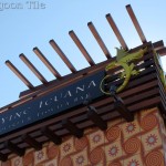 A close-up shot of the Flying Iguana signage. A stylized wooden framework holds the sign over a facade of 10" Tradewinds decorative cement tile, exclusive to Villa Lagoon Tile.