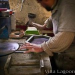 Cement tile production. The Artisan is clamping the custom hexagonal shape mold to the mold's base.