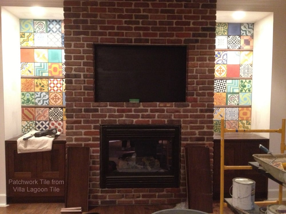 Encaustic cement tile in the back of custom shelves on either side of a brick fireplace.