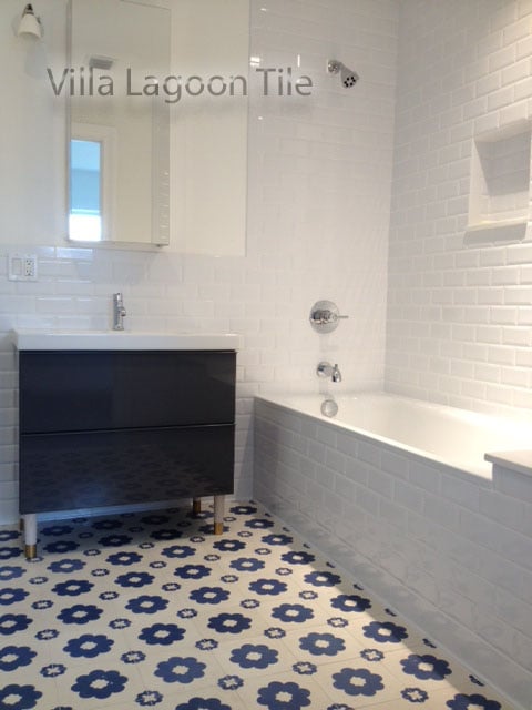 A white bathroom, accented by "Ambrose" blue-and-white cement tile by Villa Lagoon Tile.