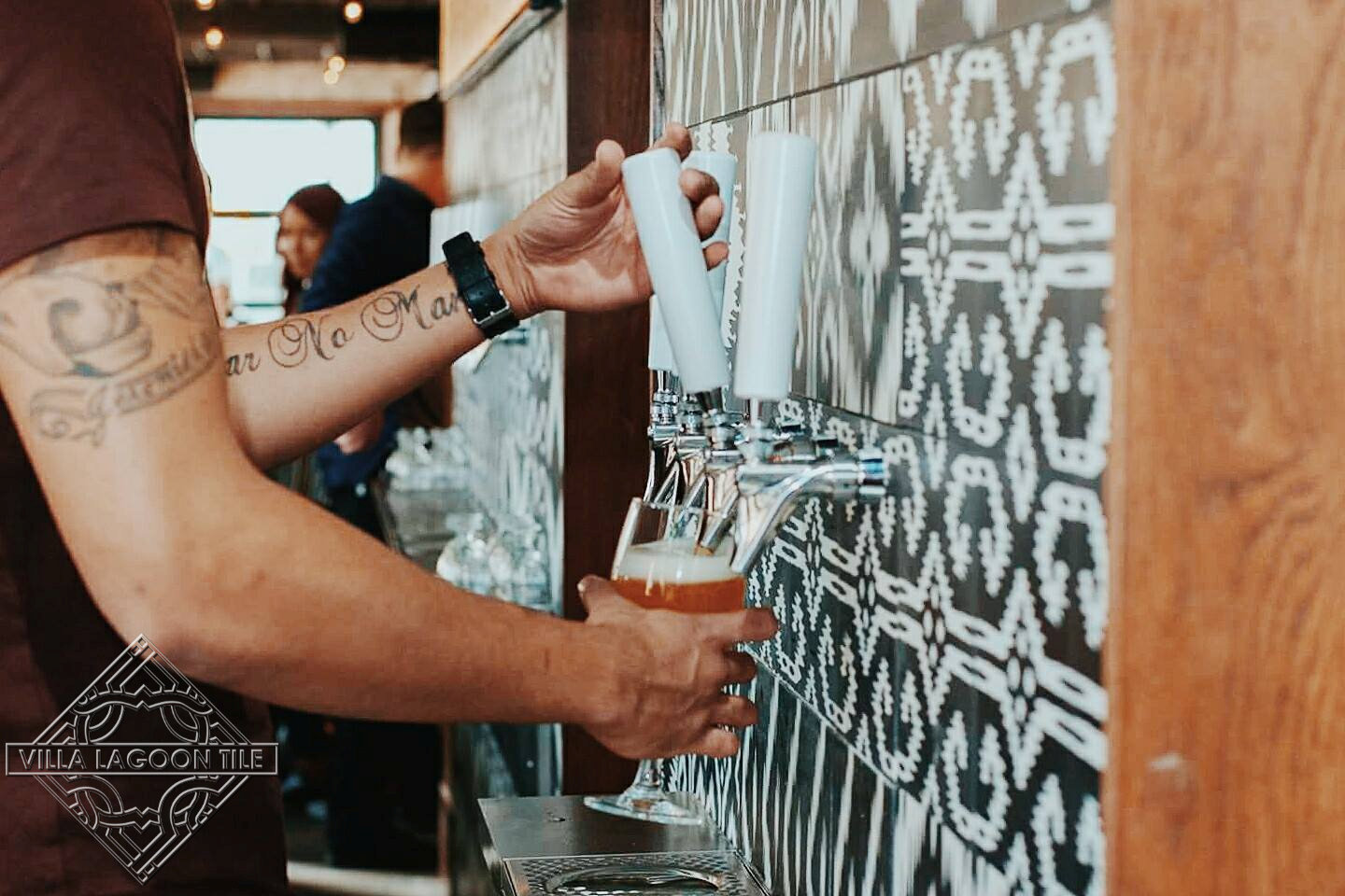 Decorative beer tap wall covered in our black and white Ikat Series cement tile.