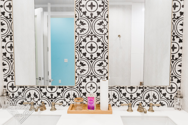 Traditional black and white quatrafoil cement tile pattern on a bathroom wall.