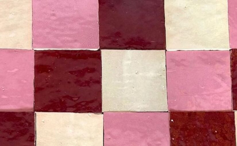 A checkerboard tile with different colors, ranging from white, to red, to pink. The tiles have a wavy texture.