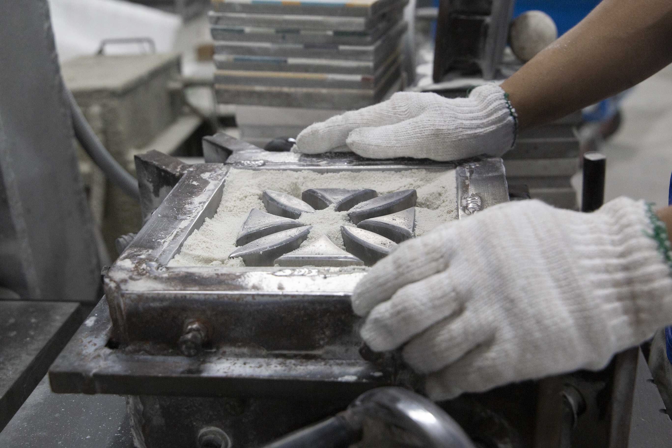 A Villa Lagoon Tile artisan creates an individual breeze block.