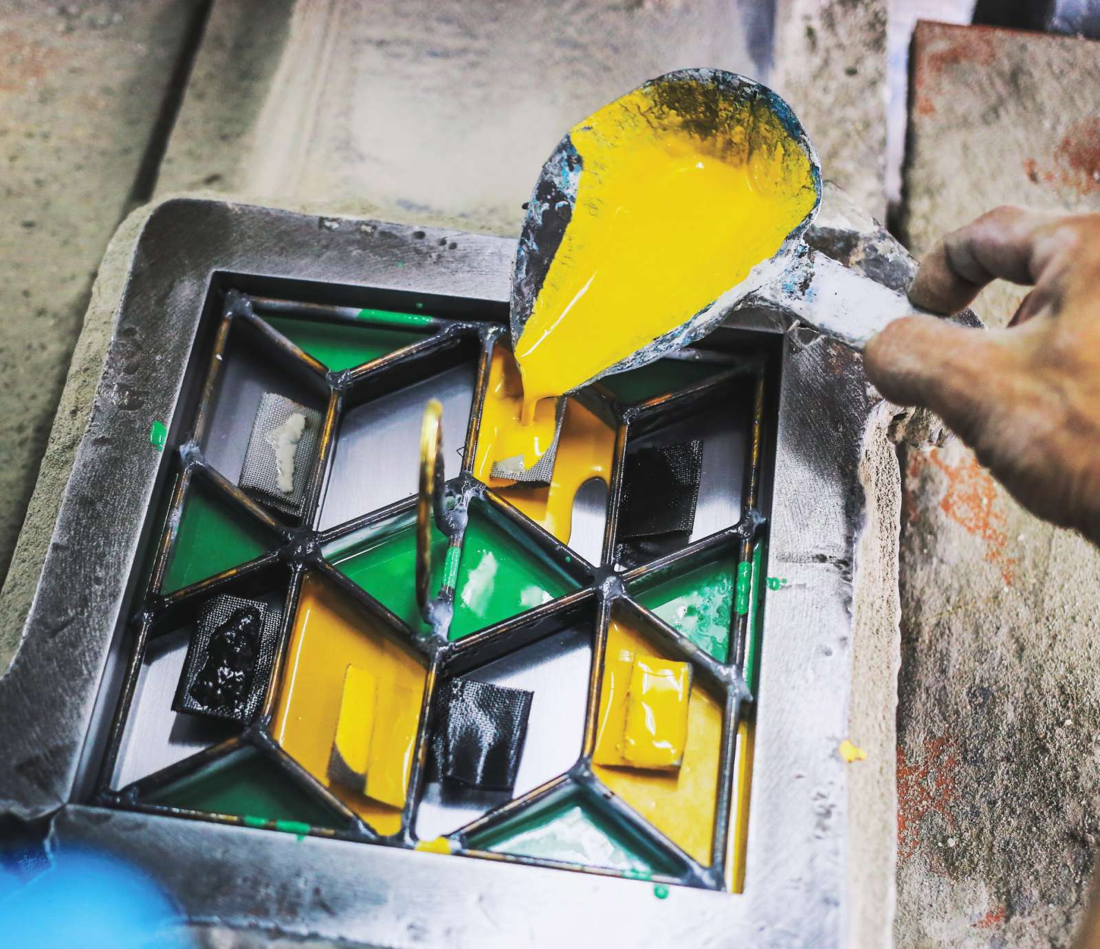 A Villa Lagoon Tile artisan hand-pours a custom design cement tile.