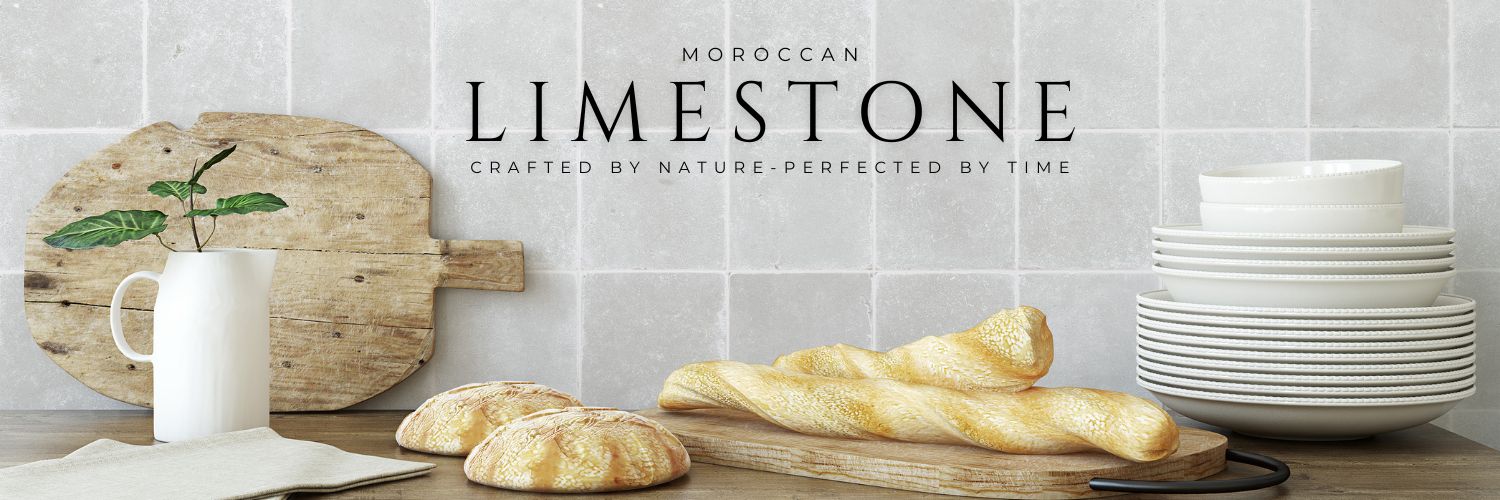 Moroccan Limestone Tiles, set as a kitchen wall, with plates, bread, and cutting boards on a table in the foreground.